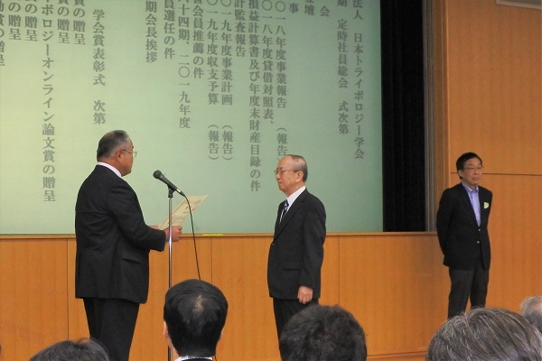学会賞表彰式のようす：功績賞で表彰される小宮広志氏（写真中央）と多川則男氏（右）