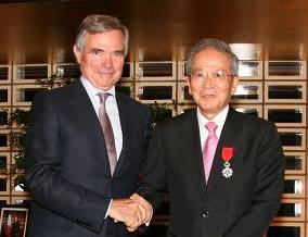 アコワイエ国民議会会長(左)から勲章を受章する鈴木会長（右）