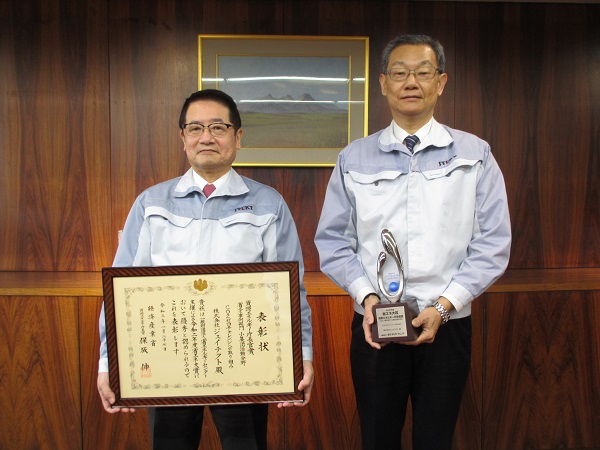 表彰状を持つ佐藤和弘社長(左)　とトロフィーを持つ佐野眞琴経営役員(右)